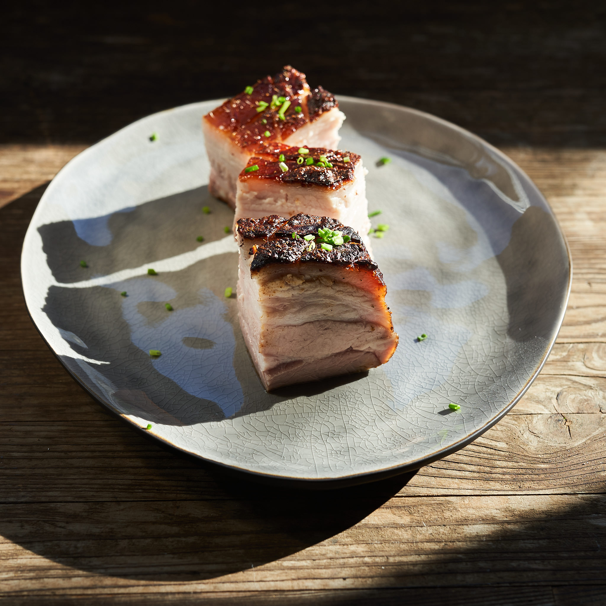 Schweinebauch vom Strohschwein serviert auf Teller