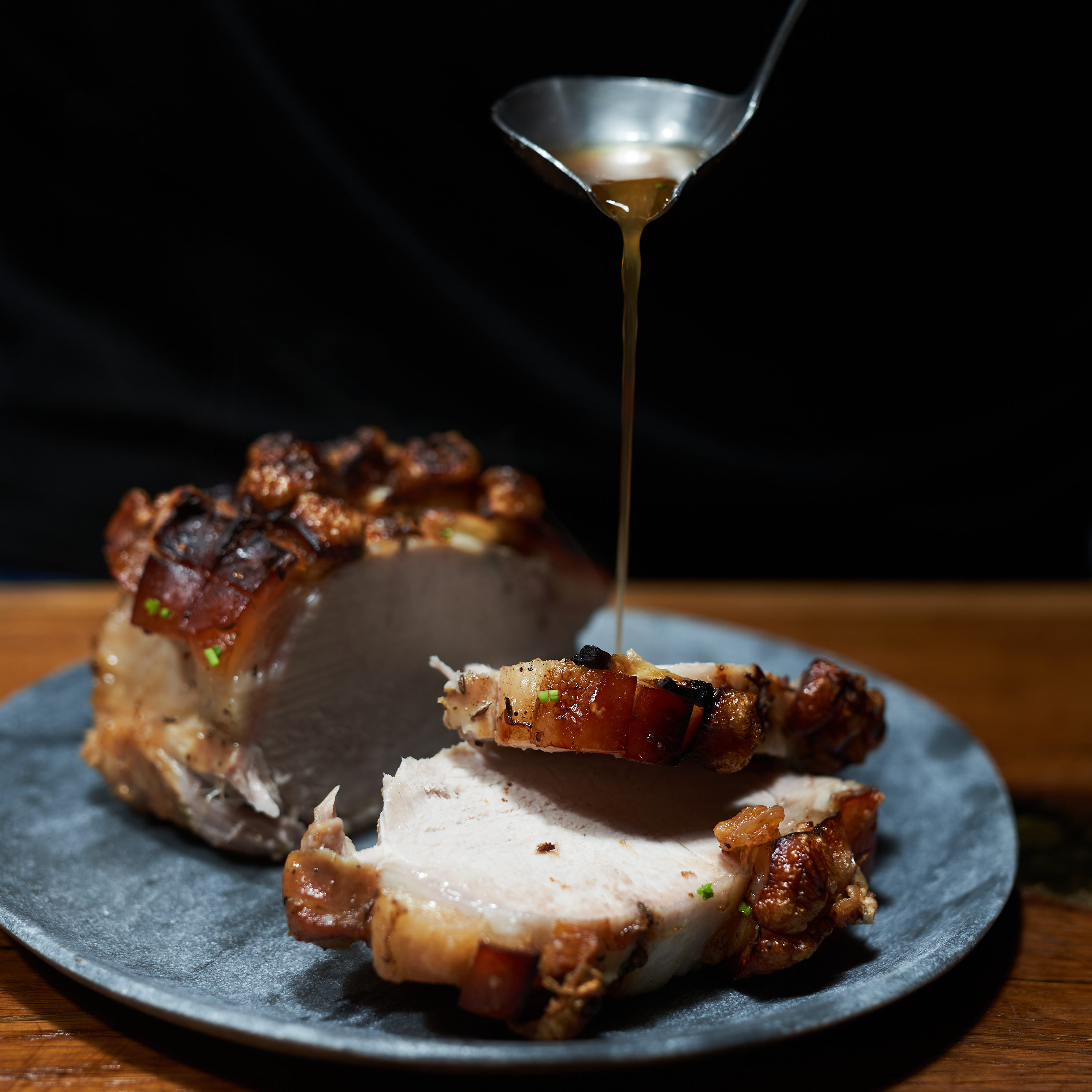 Karree mit Schwarte vom Strohschwein wird mit Bratensaft begossen