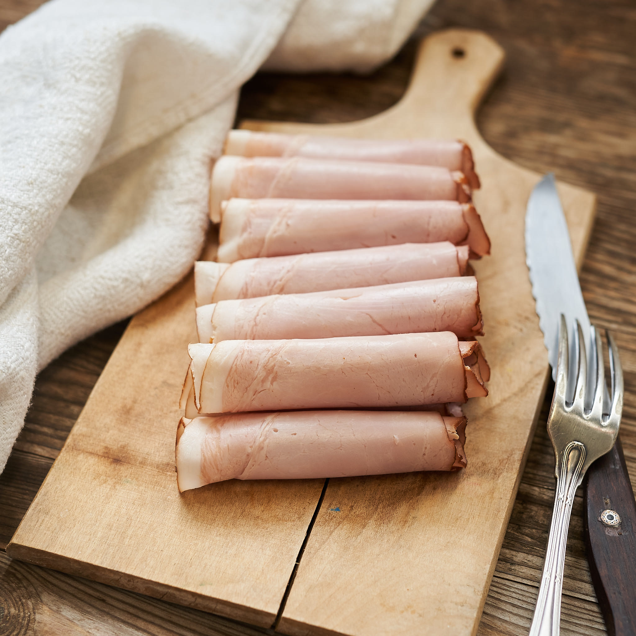 Honigkrustenschinken angerichtet auf Holzbrett