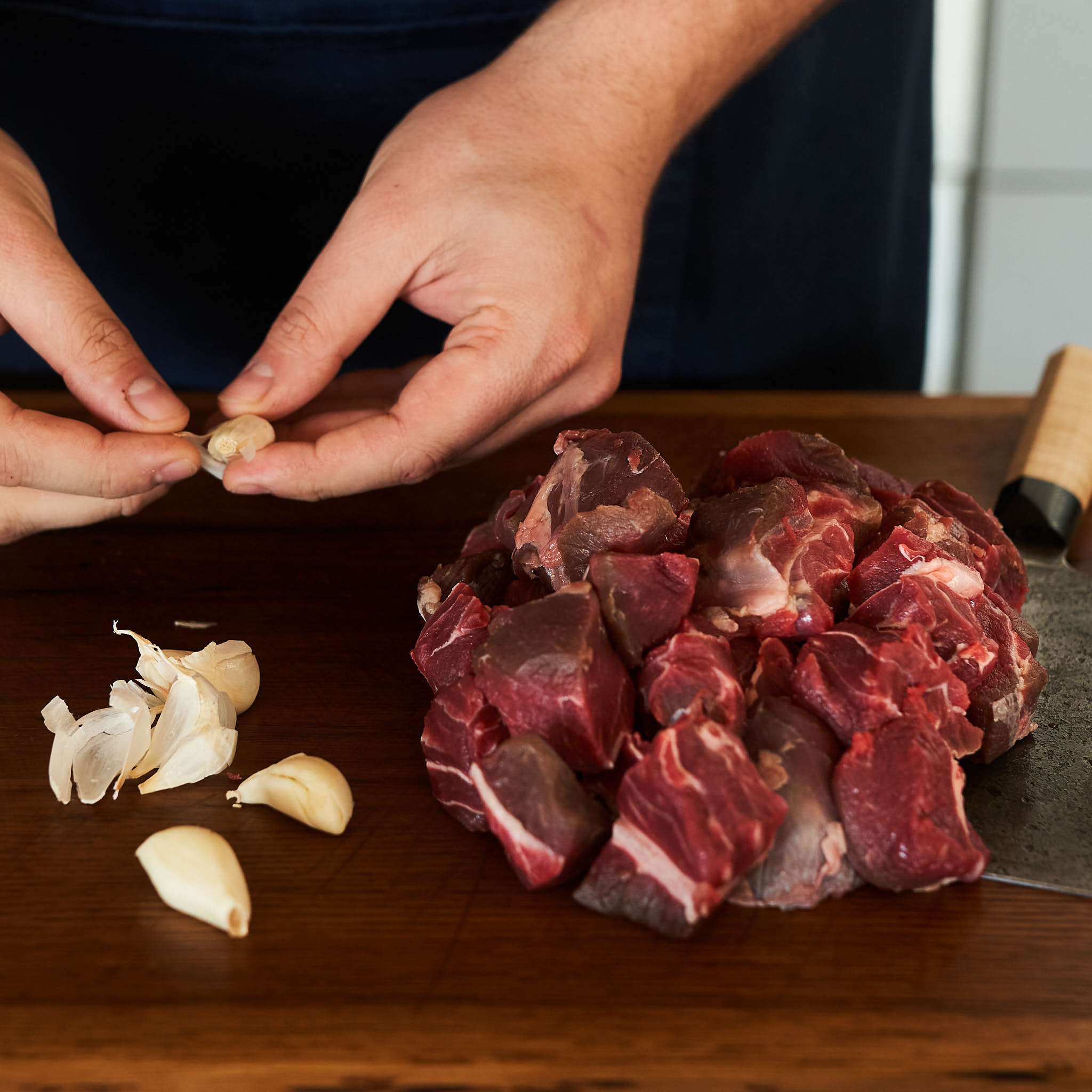Gulaschfleisch von der hinteren Wade mit frischen Knoblauchzehen