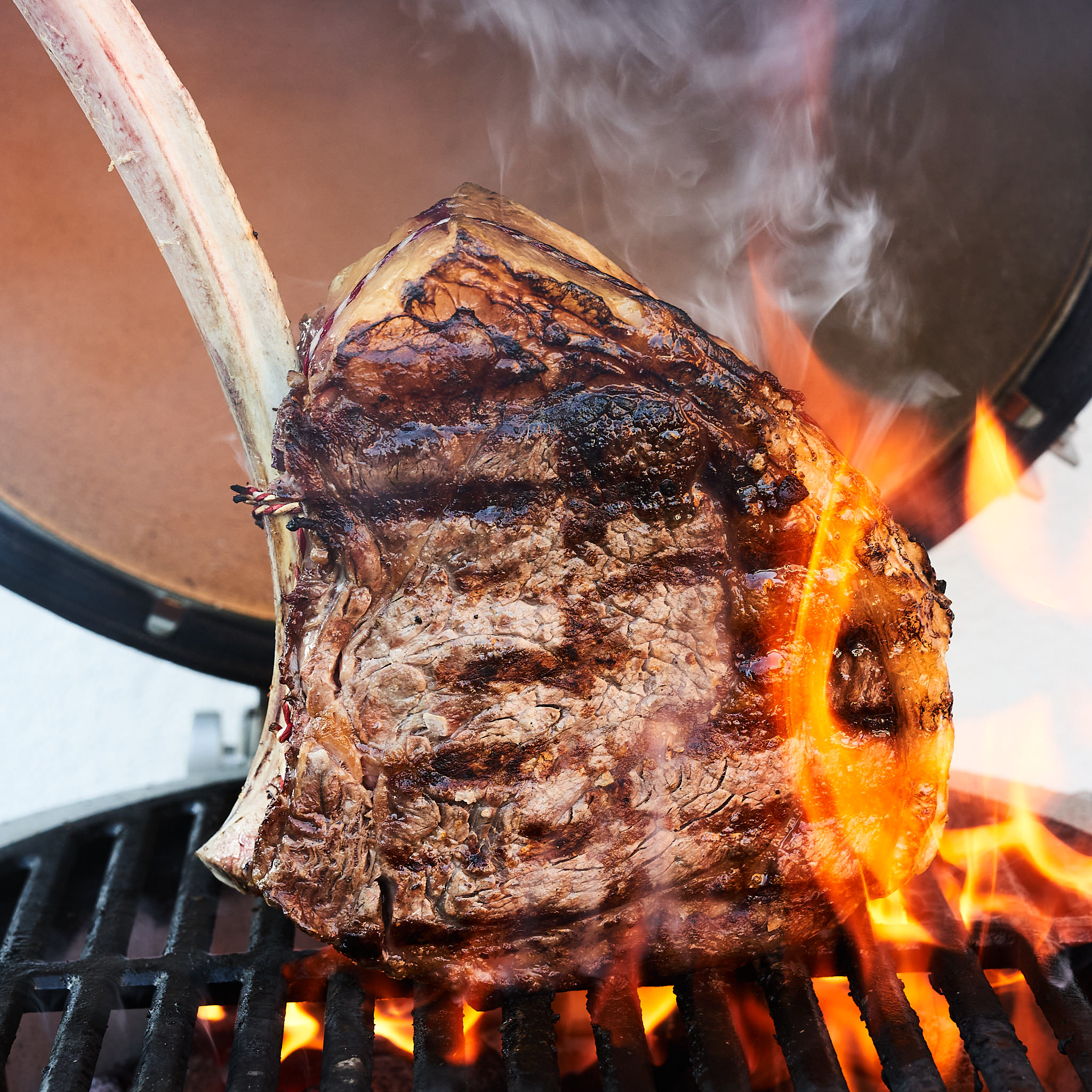 Tomahawk Steak wird über offener Flamme gegrillt