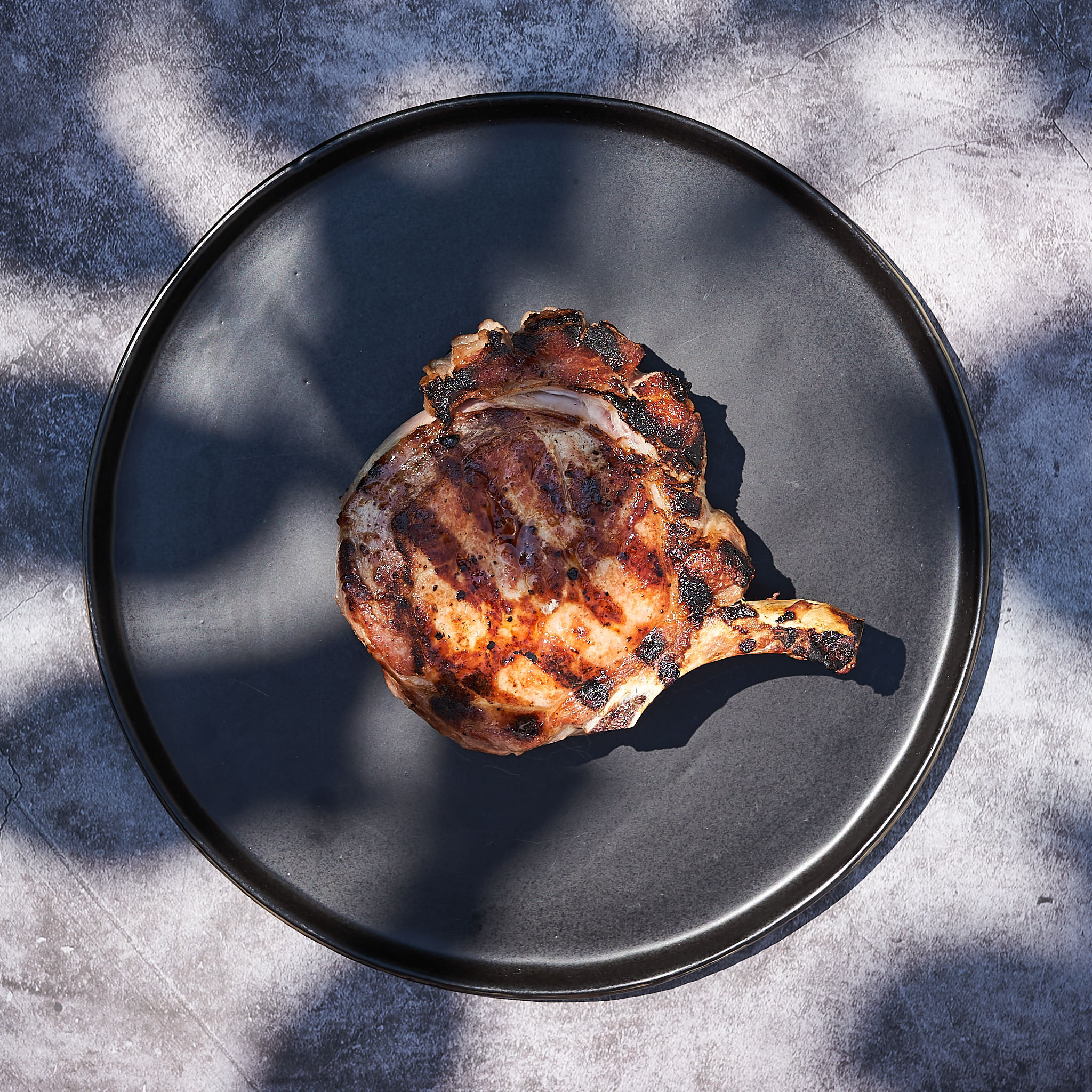 Gegrilltes Kotelette vom Strohschwein auf Teller serviert