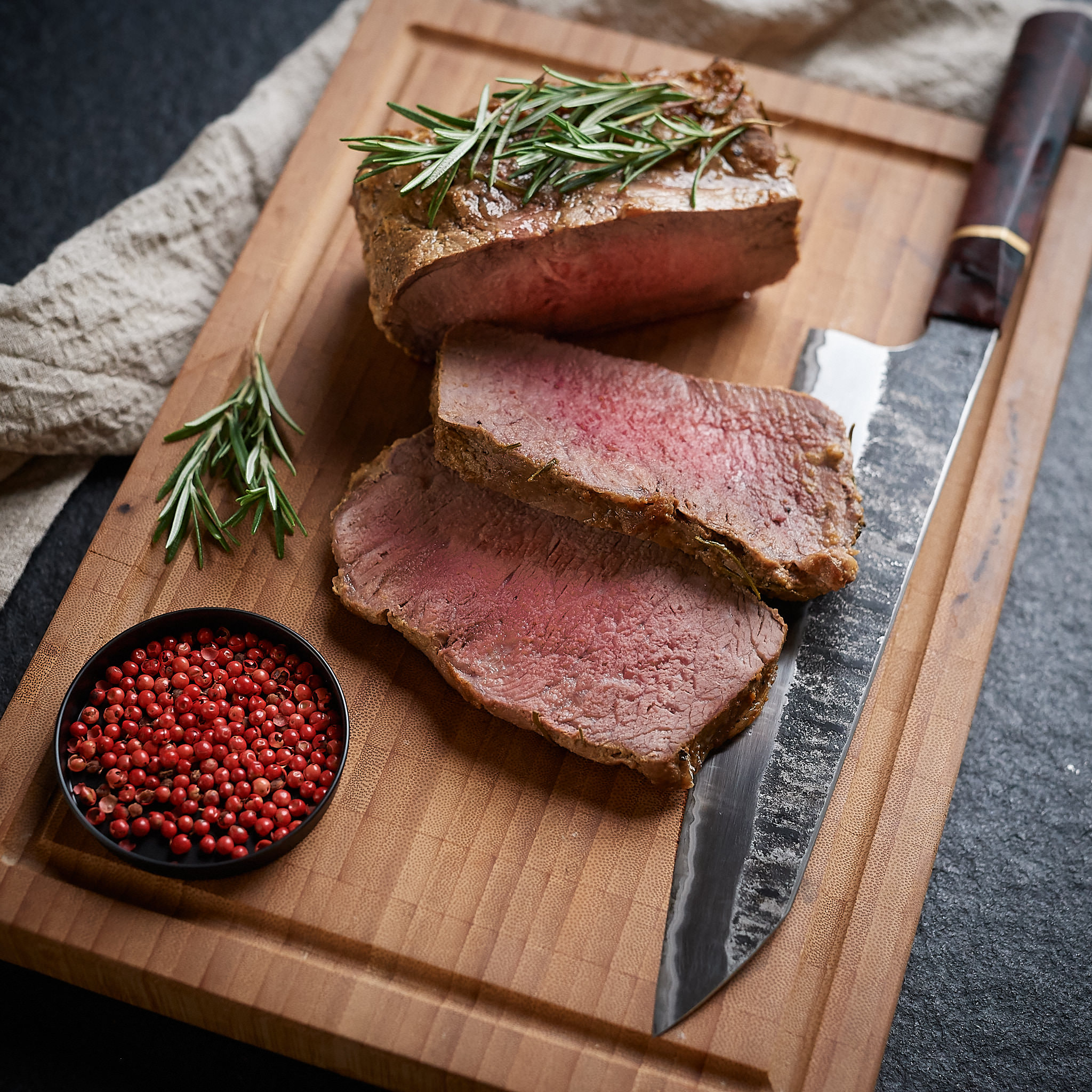 Gegrilltes Rumpsteak mit frischem  Rosmarin serviert auf Holzbrett von Fitmeat