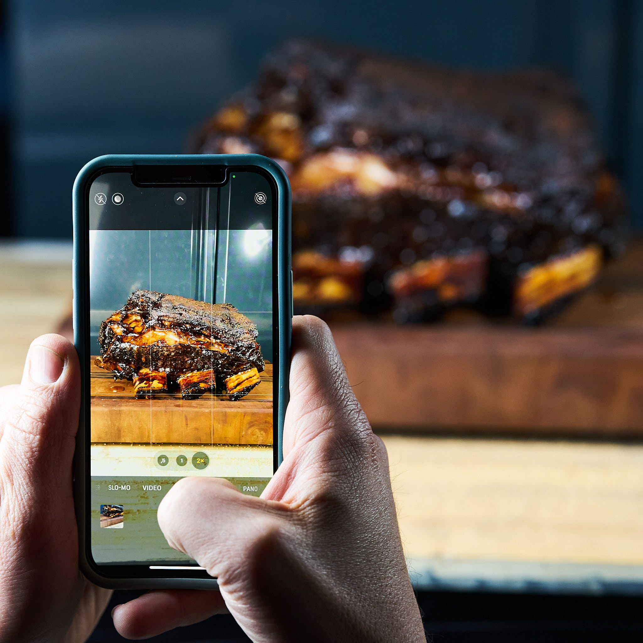 Person macht ein Foto von gegrillten Plate Ribs