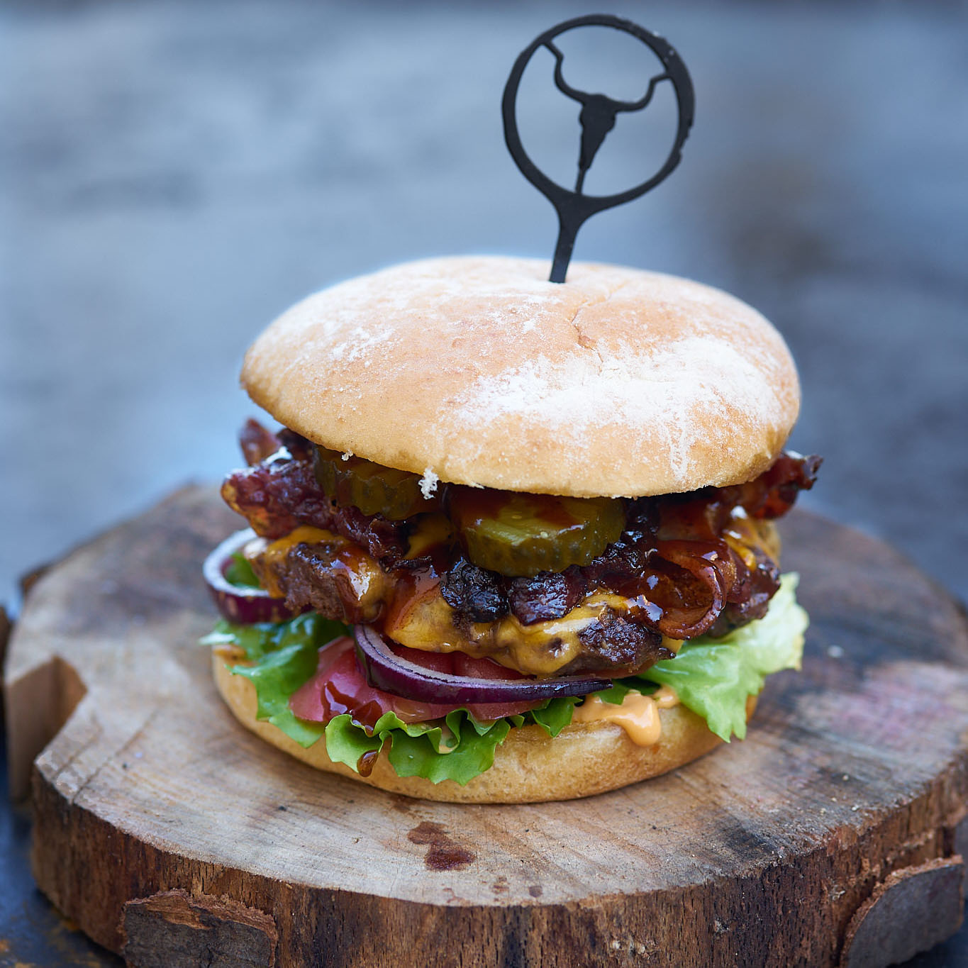 Saftiger Burger mit Patties von Fitmeat, Salat, Zwiebel, Kaese und Bacon