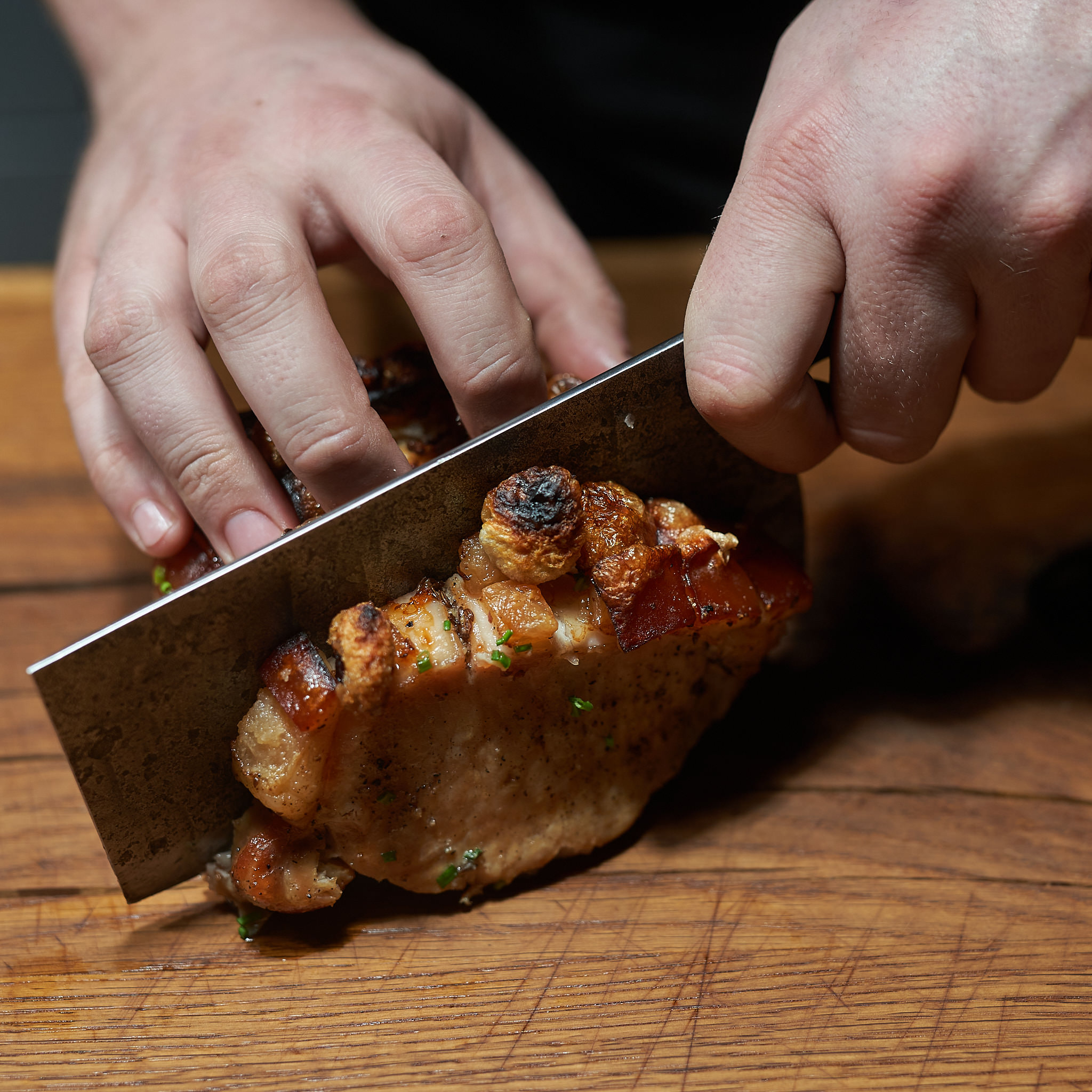 Karree mit Schwarte wird angeschnitten