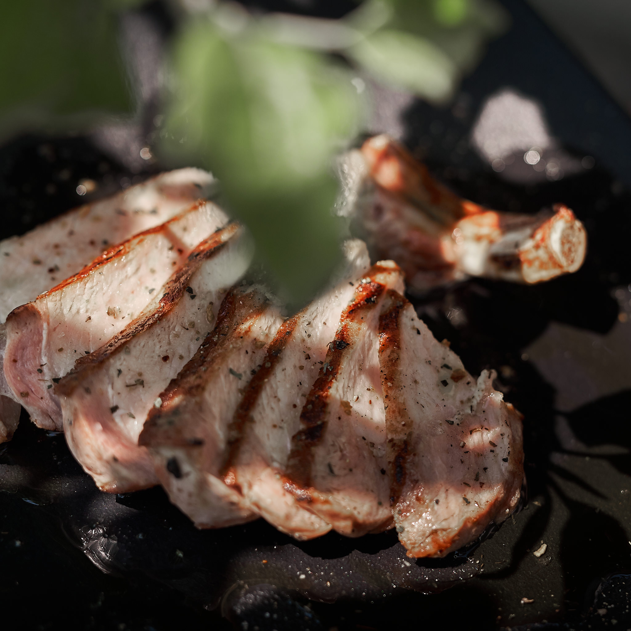 Gegrilltes Kotelette vom Strohschwein auf Teller serviert und fein aufgeschnitten