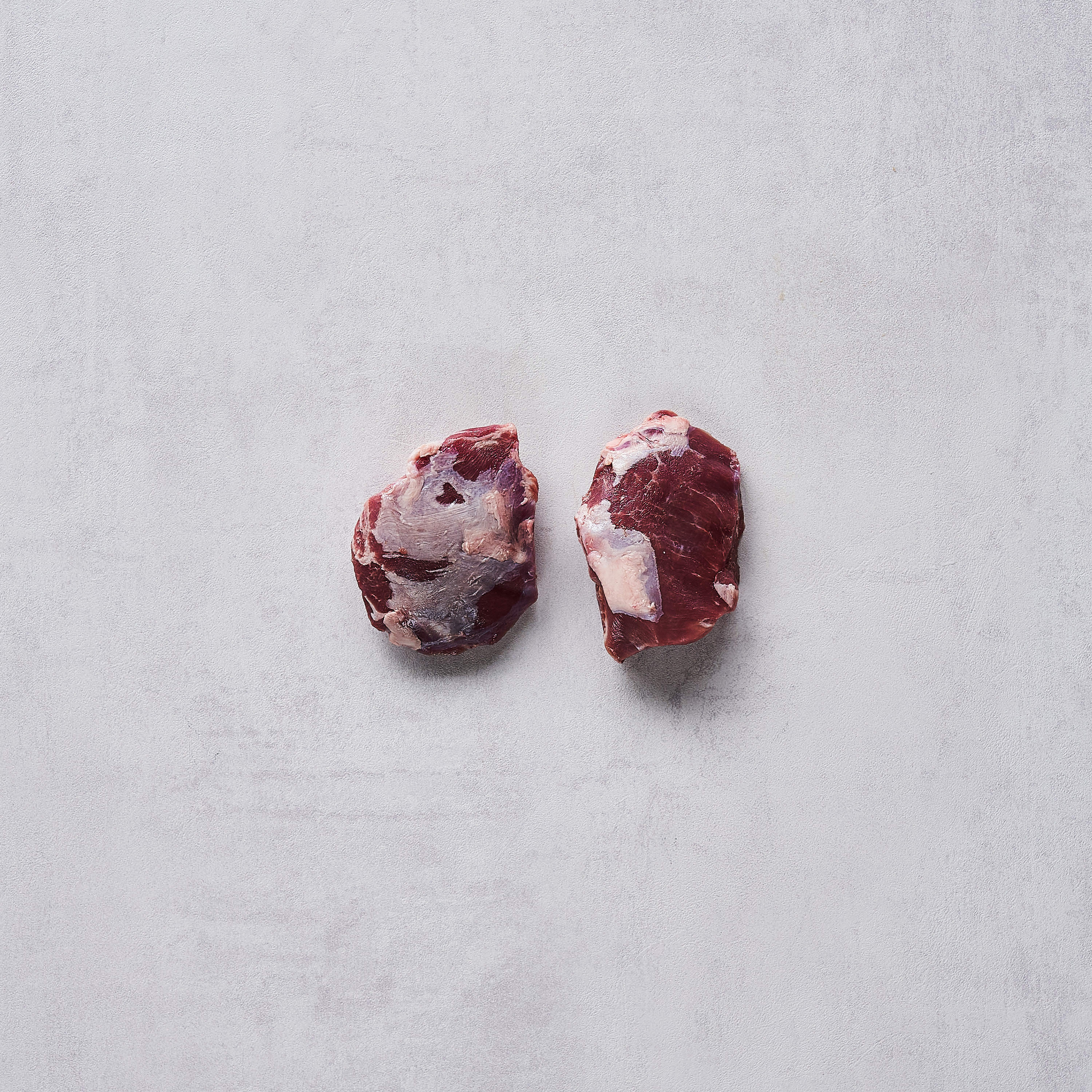 Produktaufnahme von zwei Schweinsbackerl auf weißem Hintergrund