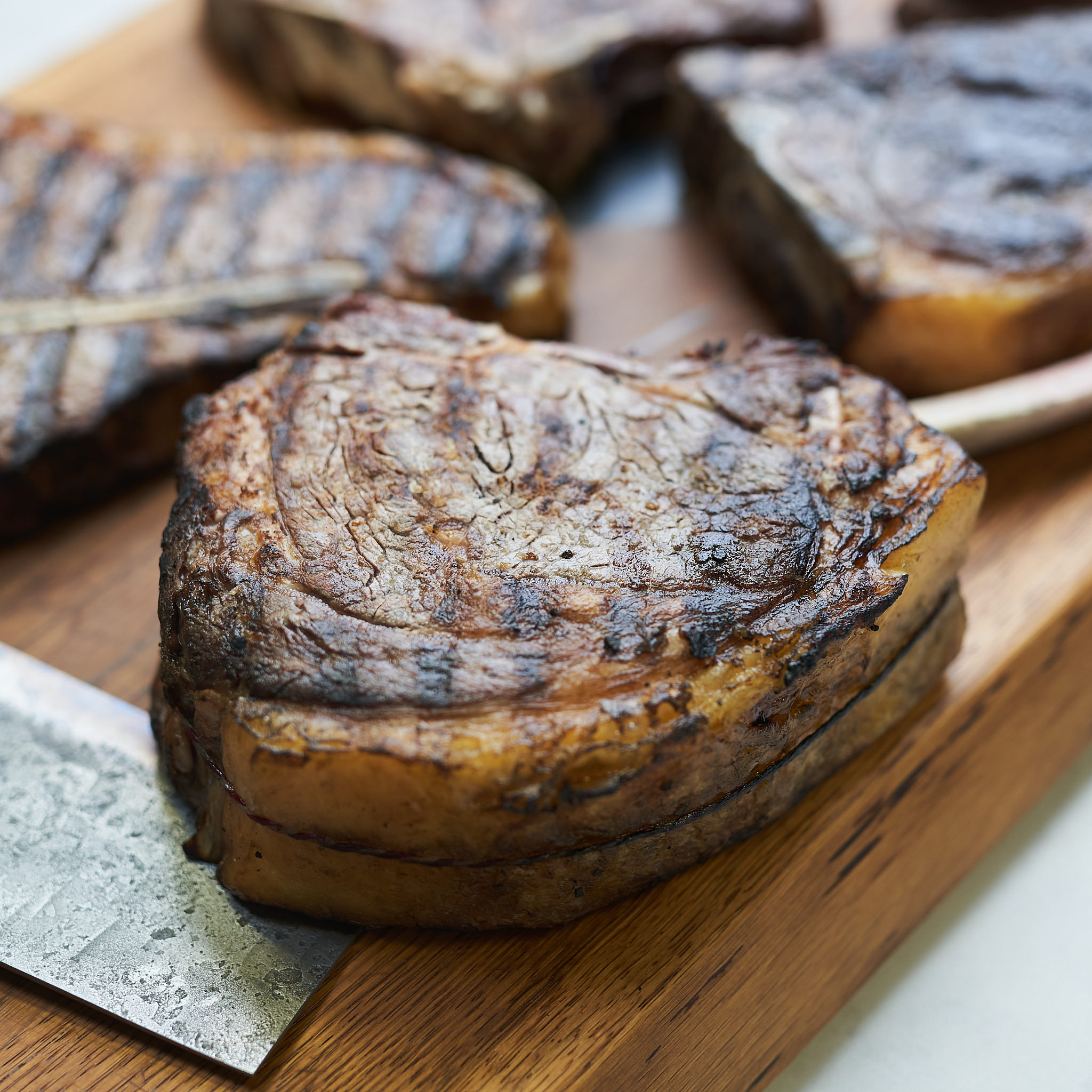 Gegrillte Steak-Cuts mit Roestaromen auf Holzplatte