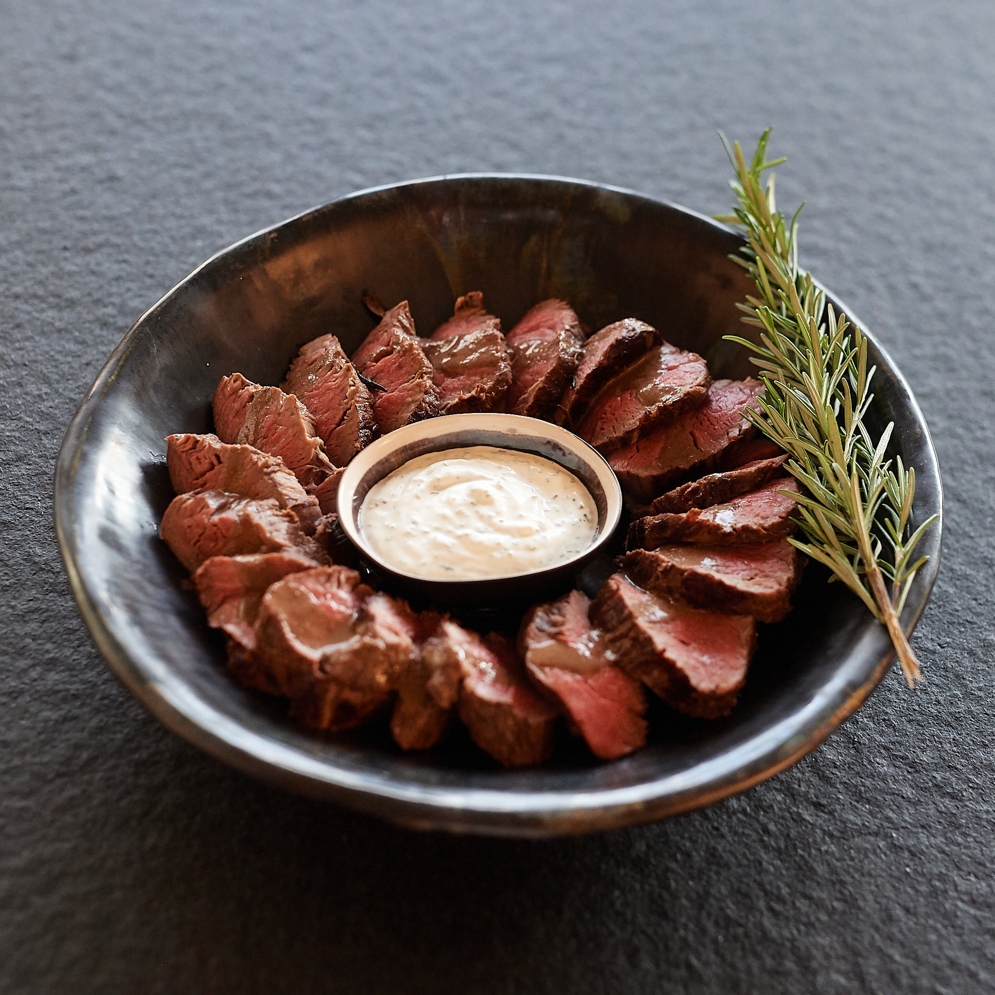 Feine Streifen vom Rinderfilet in Schuessel serviert mit selbstgemachter Sauce