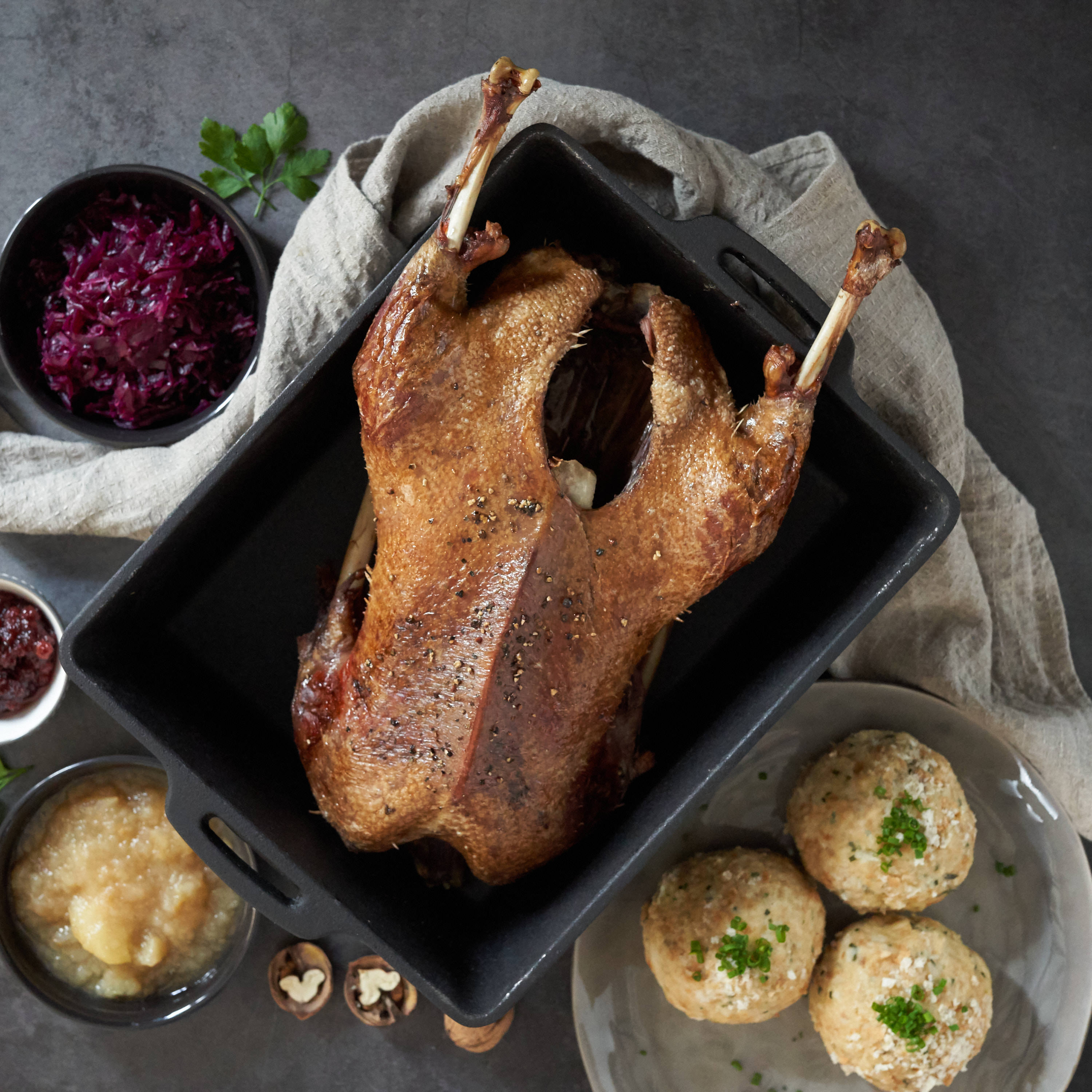 Martini-Gansl im Bräter mit Knoedeln und Rotkraut serviert