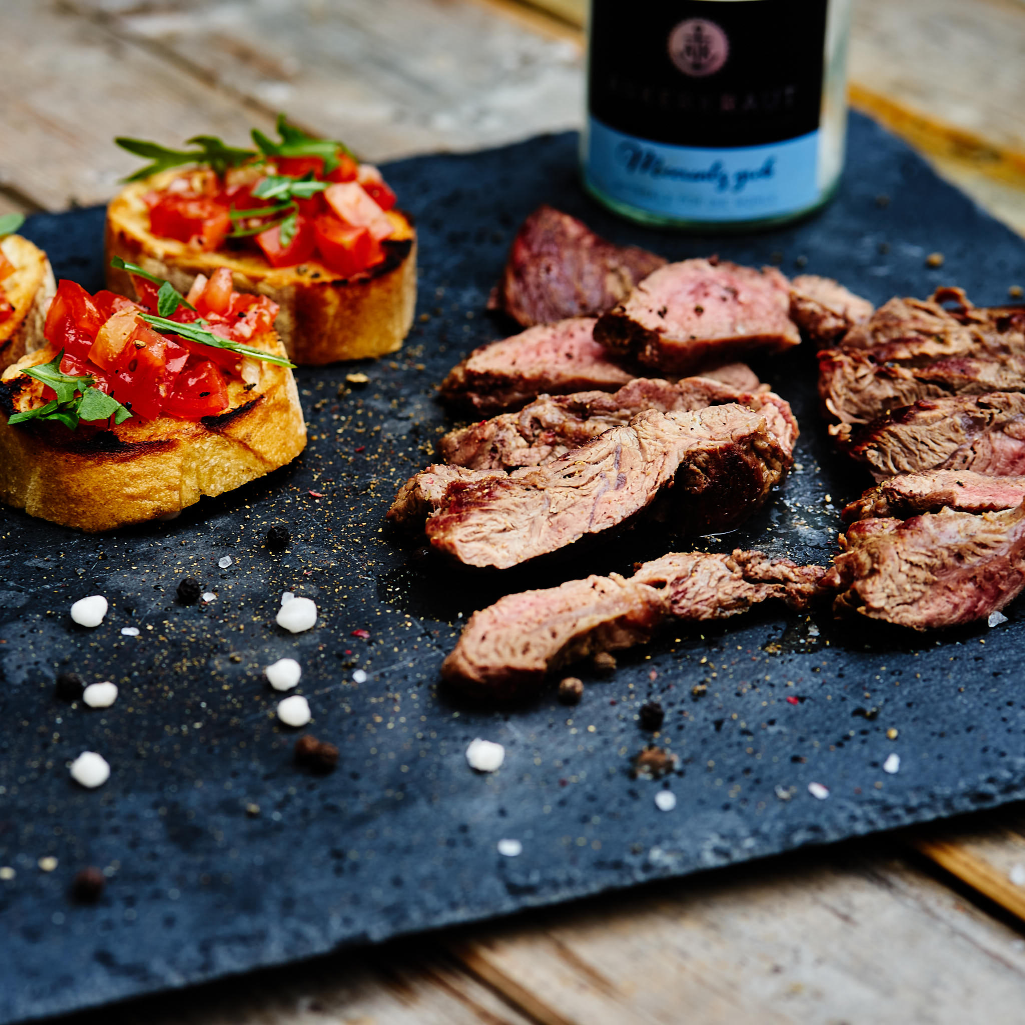 Fledermaus Steak fein aufgeschnitten auf Steinplatte serviert mit Bruschetta