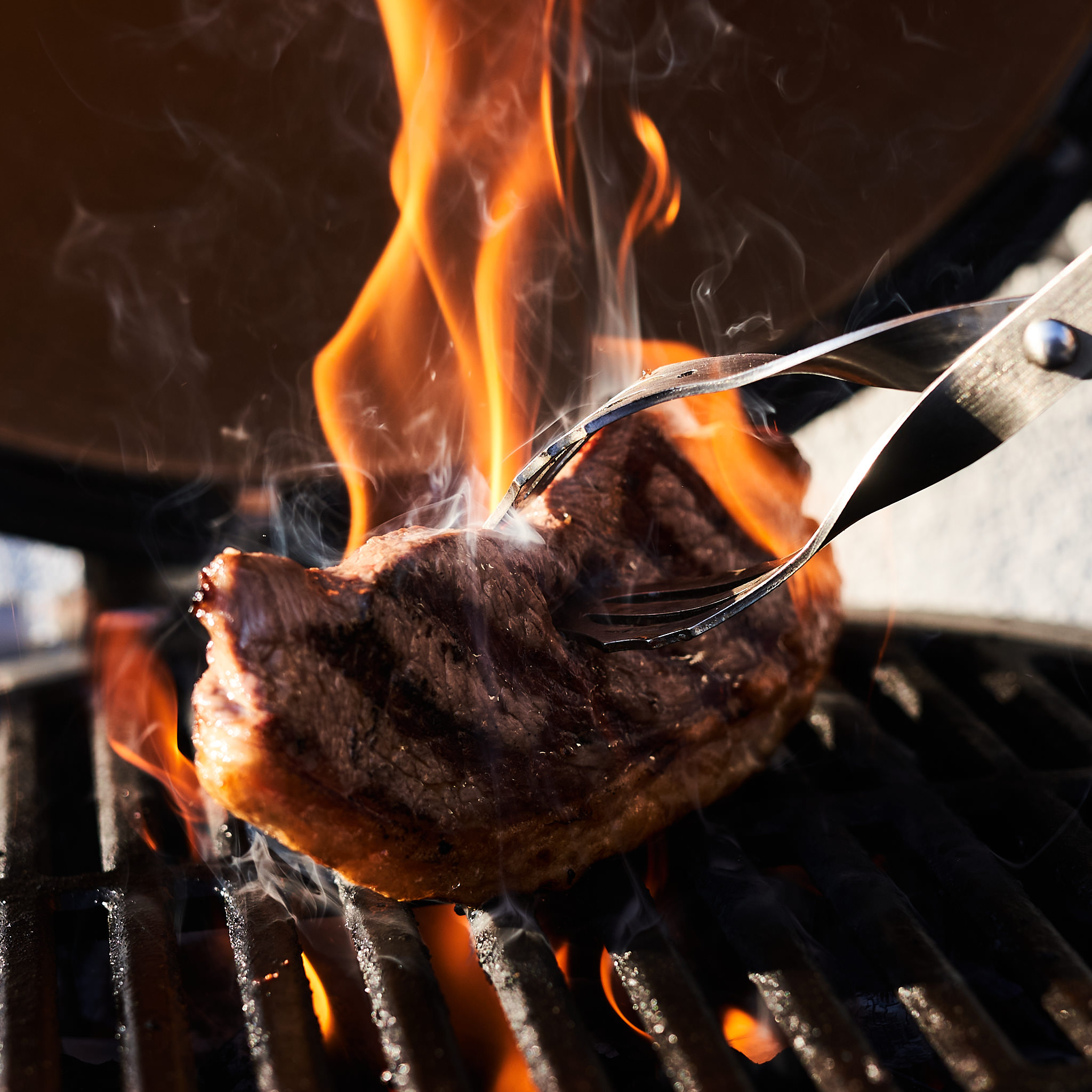 Picanha Steak wird ueber offener Flamme gegrillt