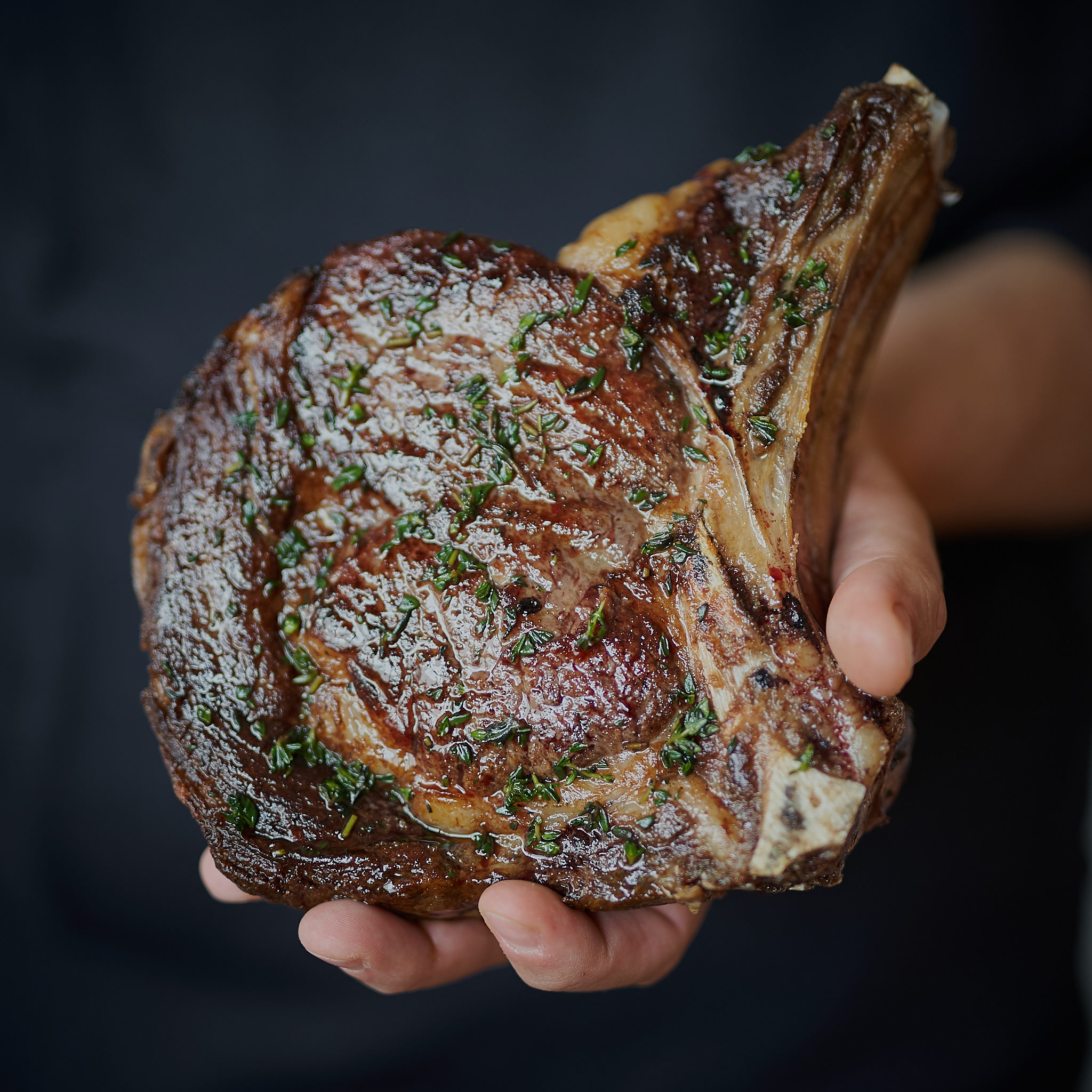 Sebastian haelt Rib Eye Steak on Bone  in der Hand