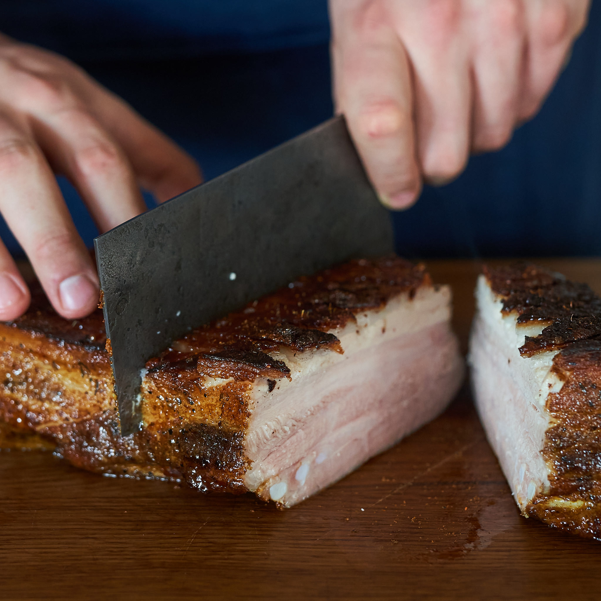 Goldbraun gebratener Schweinebauch vom Strohschwein beim Anschnitt